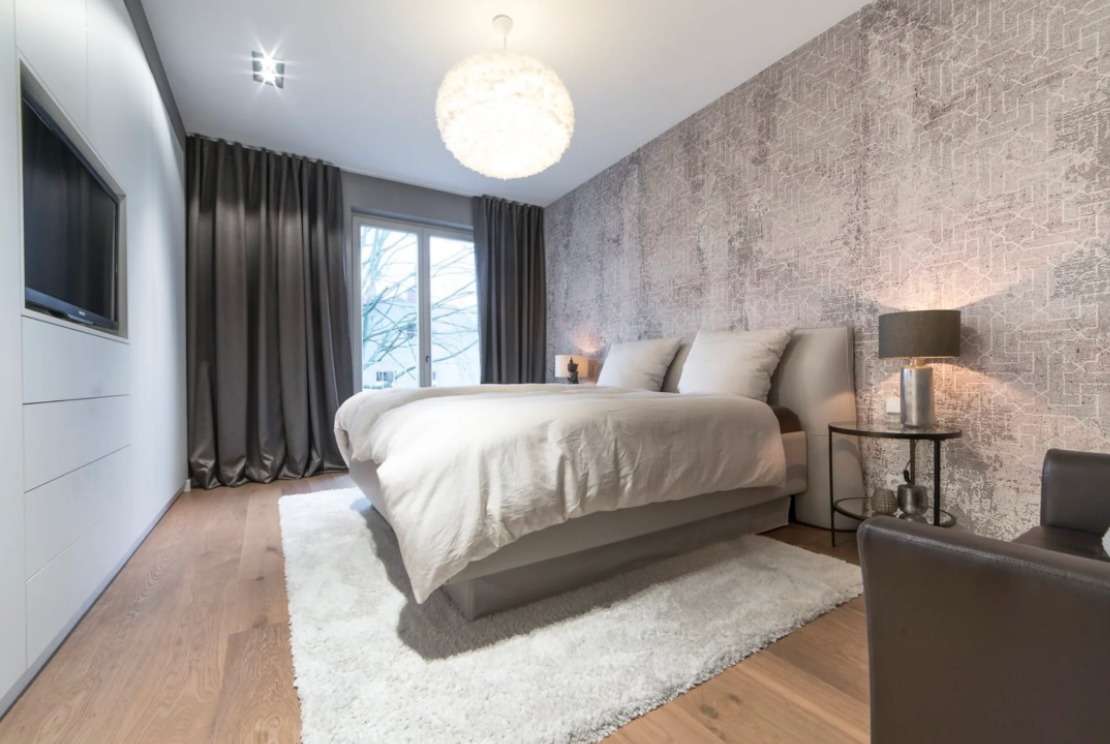 Schlafzimmer mit Tapete und Vorhängen mit Einbauwand und TV